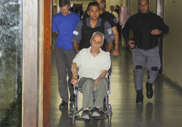 Priest Nicola Corradi Handcuffed to a Wheelchair